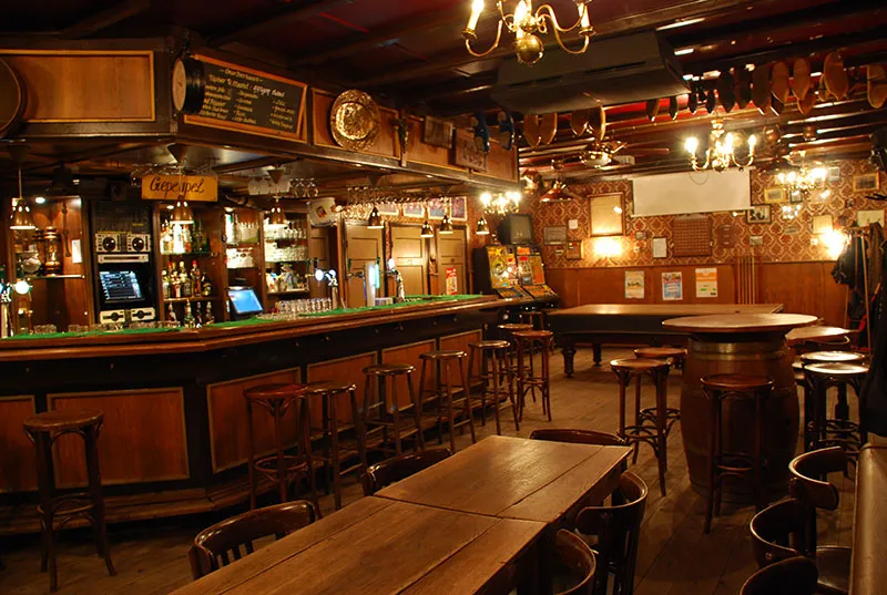 De bar van het bruin café met houten tapkast