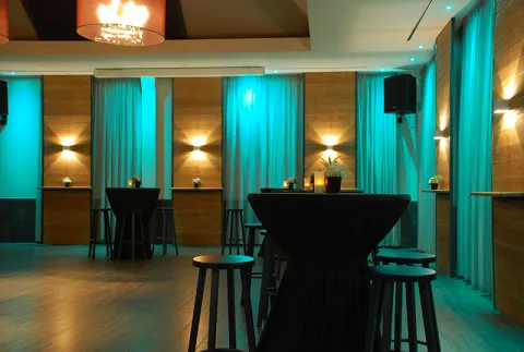 Statafels in turquoise licht in de zaal