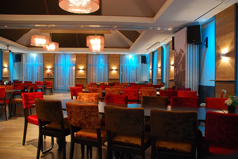 De zaal met tafels in blauw sfeerlicht